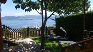 Eine Terrasse mit Blick auf einen Hafen und Berge.