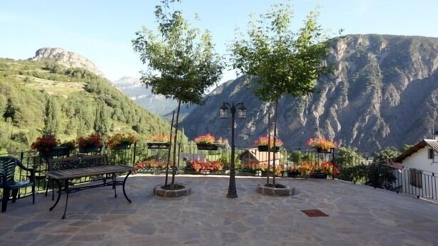 A patio area with a bench, potted plants, and a view of mountains. - Miguelo apartments for 6 people (Plan)