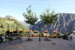 A patio area with a bench, potted plants, and a view of mountains. - Miguelo apartments for 6 people (Plan)