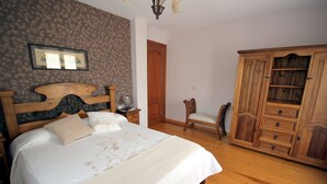 A bedroom with a wooden bed, a wardrobe, and a chair. - Miguelo apartments for 6 people (Plan)