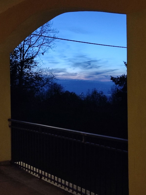A balcony with a view of the sky and trees.