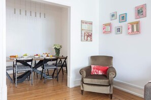 A dining area with a table and chairs, a sofa, and wall decorations.