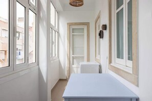 A narrow hallway with white walls, a white radiator, and a white table. - Casa da Avenida IV Lisboa (Lisbon)