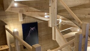 Ein Holzinnenraum mit einer Treppe und einem Bärenposter.