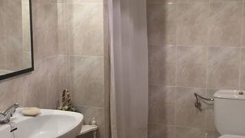 Bathtub, hair dryer, towels, toilet paper