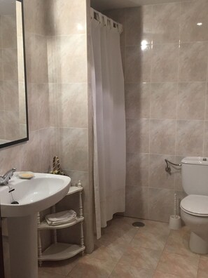 Bathtub, hair dryer, towels, toilet paper