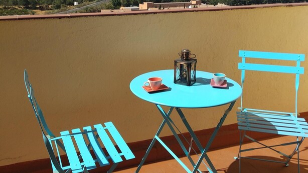 A terrace with a table and two chairs, overlooking a hilly landscape. - Nevada Apartaments, between Granada and Sierra Nevada (Cenes de la Vega)
