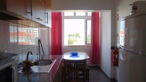 A kitchen with a window, a sink, a stove, and a refrigerator. - WELL ME WANT 1, apartment with pool 5km from Lisbon and Costa da Caparica (Feijó)
