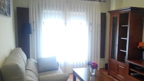 Uma sala de estar com sofá, mesa de centro e armário.