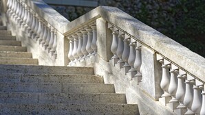 Eine steile Steintreppe mit Geländern, die nach oben führt.