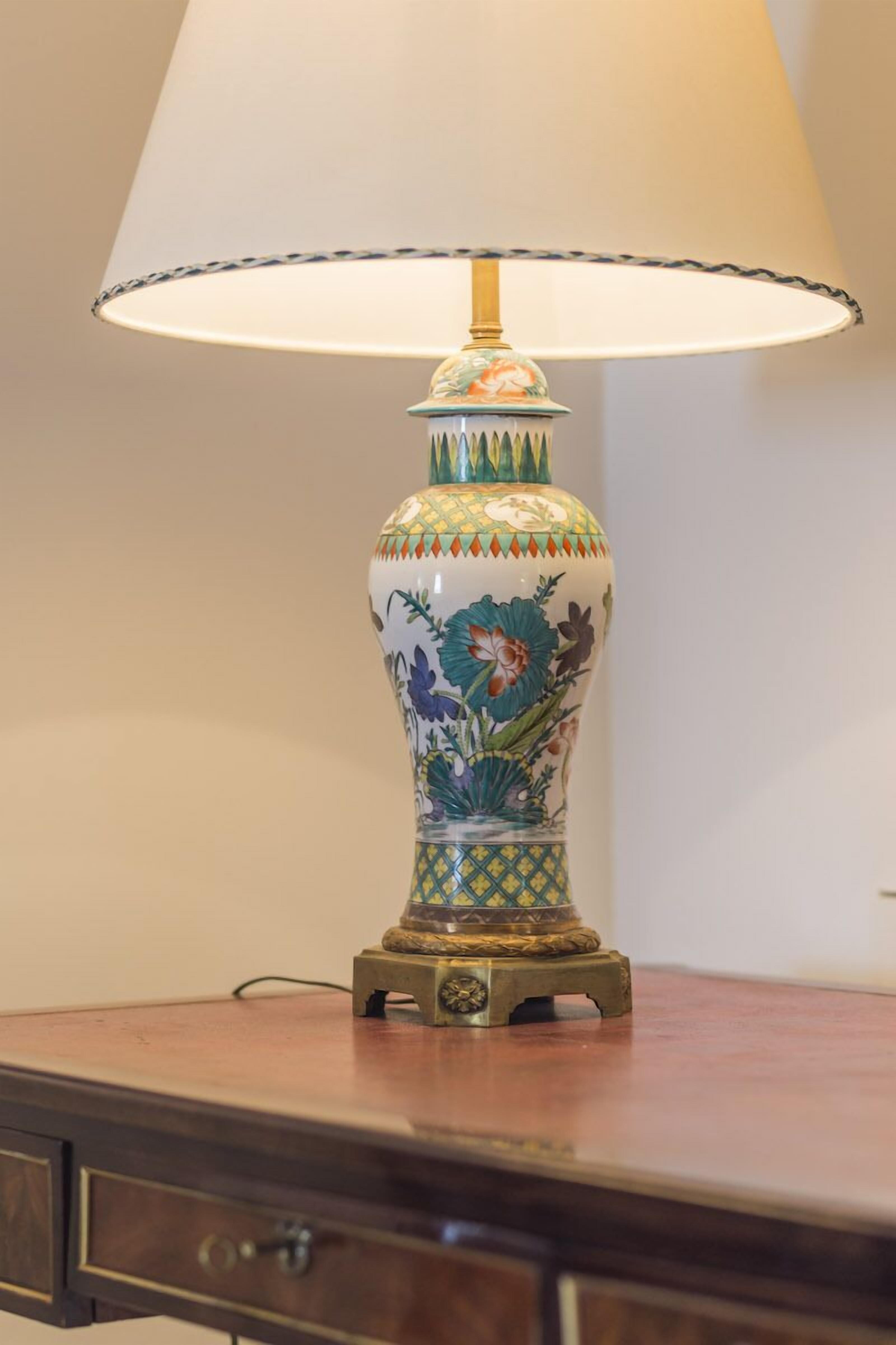 Una lámpara de mesa con diseño floral sobre una mesa de madera.