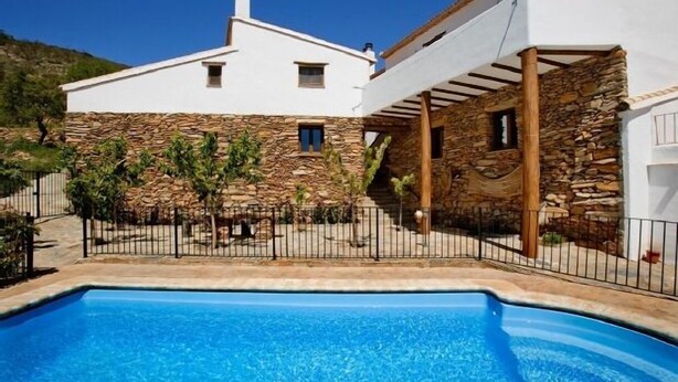 A modern house with a stone facade, a pool, and a pergola. - Rural house (rental entire) Reul Alto Cortijos Rurales for 6 people (Laroya)