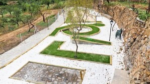 A landscaped garden with geometric pathways, a central tree, and a stone feature. - Rural house (rental entire) Reul Alto Cortijos Rurales for 6 people (Laroya)