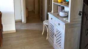 A kitchen with a white cabinet, a yellow vase, and a hanging plant.