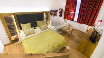 A bedroom with a bed, a sofa, a desk, and a TV.