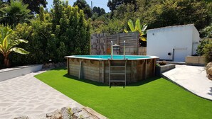 A backyard with a wooden pool, artificial grass, and a stone wall. - Rural house (full rental) Finca Los Ciruelos for 2 people (Icod de los Vinos)