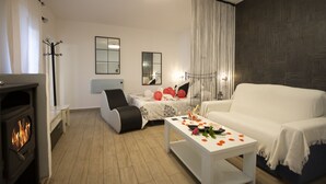 Un salon moderne avec une cheminée, un canapé, une table basse décorée et un lit agrémenté de ballons.