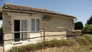 Un edificio de piedra con tejado de tejas, cerca de madera y un letrero que dice "La Saie".