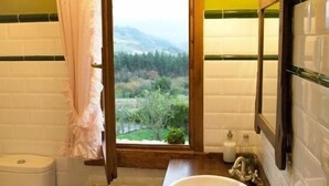 A bathroom with a view of a forest through a window, a sink, and a toilet. - Rural apartment El Mirador de Cazanes for 2 people (Villaviciosa)