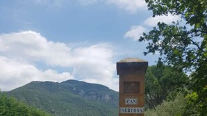 A rural road with a stone wall and a sign reading "CAN SERVOSA". - Self catering Can Servosa for 11 people (Sales de Llierca)
