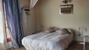 A bedroom with a bed, two bedside tables, a nightstand, a picture on the wall, and a window with curtains. - Self catering Can Servosa for 11 people (Sales de Llierca)