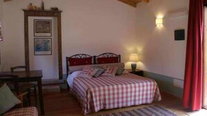 A bedroom with a bed, a desk, a chair, and a lamp. - L'AGLIENTU CALLA ROOM (Loiri)