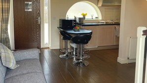 Une cuisine moderne avec un coin repas, un plancher en bois et un escalier.