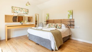 Un dormitorio con una cama, un escritorio de madera, un espejo y decoración en la pared.