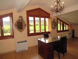 A dining area with a large table and chairs, large windows with views of a green landscape, and a chandelier. - Rural apartment Elai etxea for 4 people (Ribera Alta)