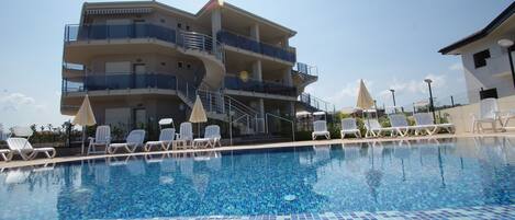 Guests can enjoy a poolside retreat with lounge chairs and umbrellas.