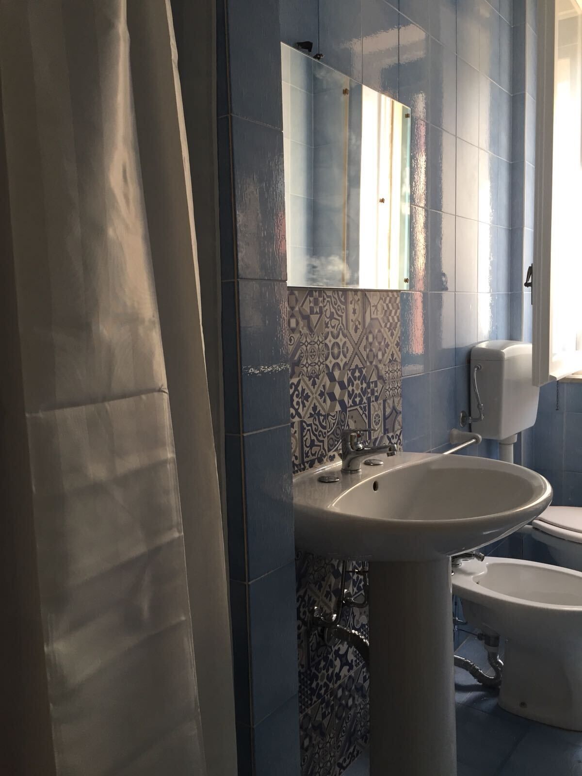 Une salle de bain avec un lavabo, des toilettes et un miroir.