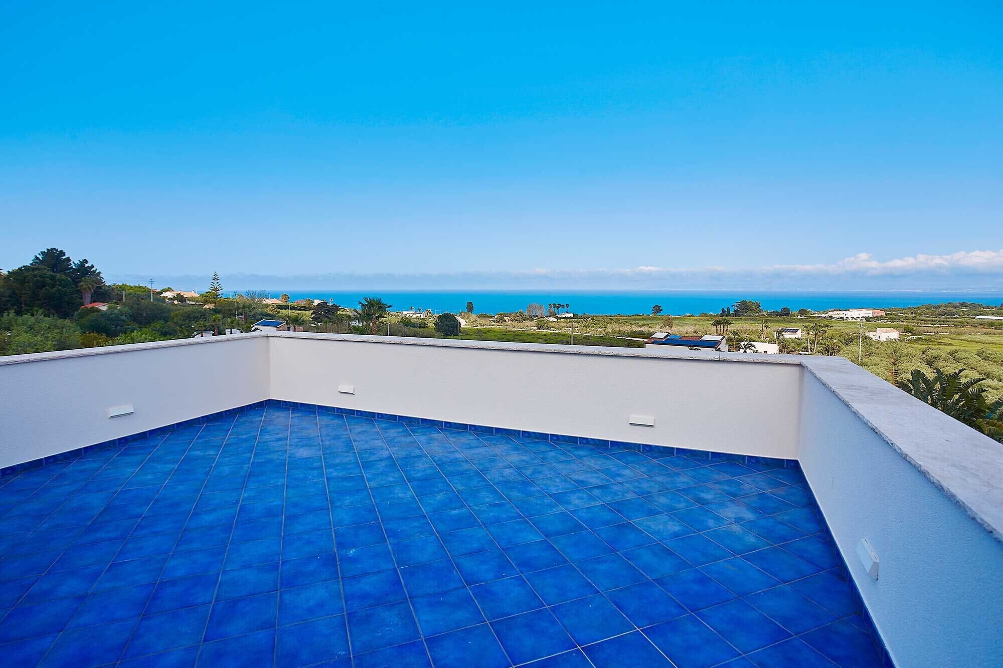 Ein Pool auf dem Dach mit freiem Blick auf das Meer und die umliegende Landschaft.