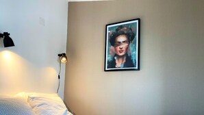 A bedroom with a bed, a wall-mounted lamp, and a framed picture. - Riverview Bright Studio @Graça. New Deco 2023! (Lisboa)