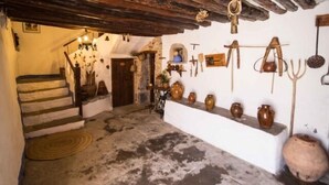A rustic interior with a stone staircase, a shelf with pottery, and a wooden ceiling. - Casa Javier for 4 people (Rodellar)