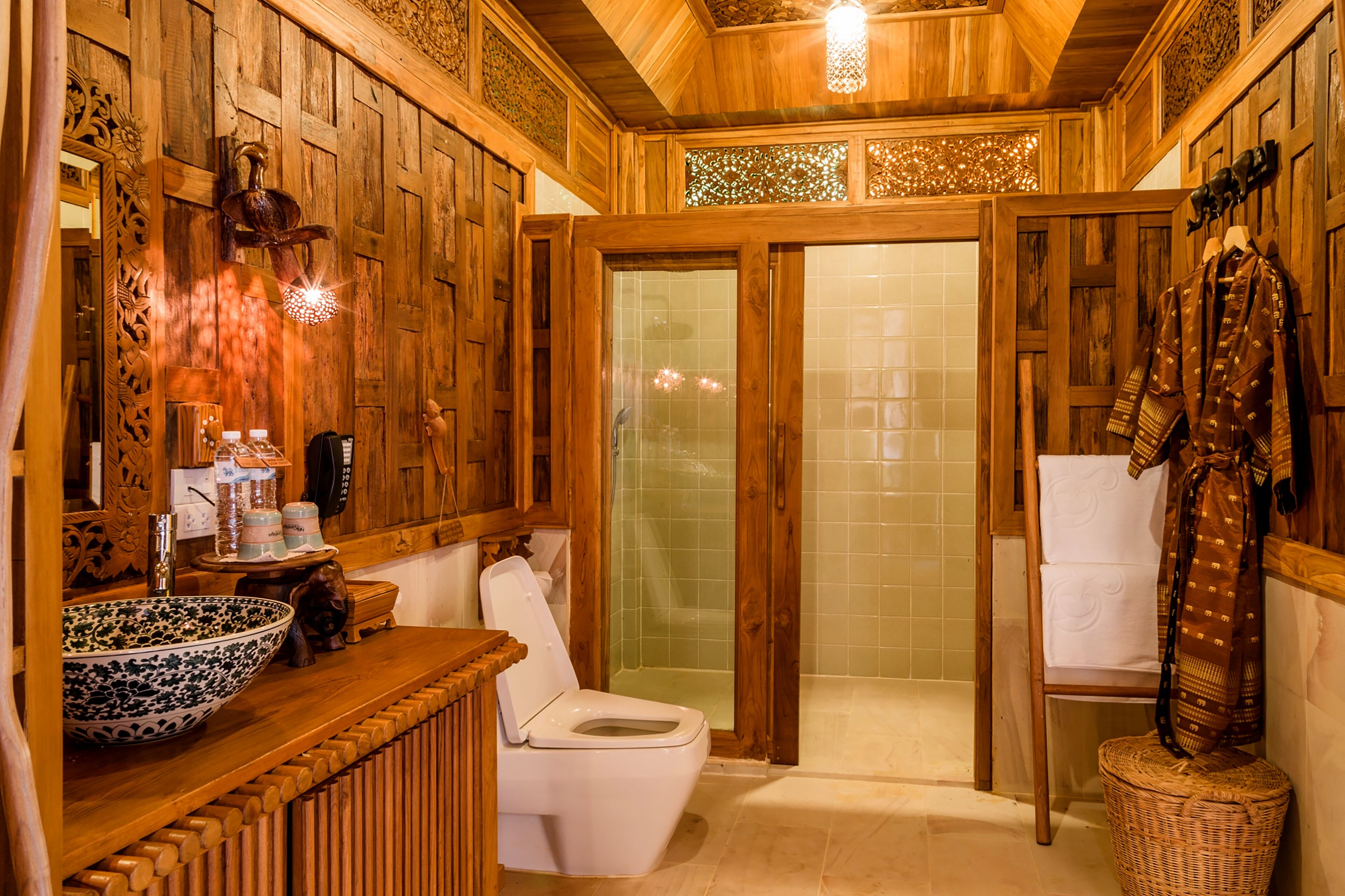 Un baño de madera con un lavabo grande, inodoro y zona de ducha.