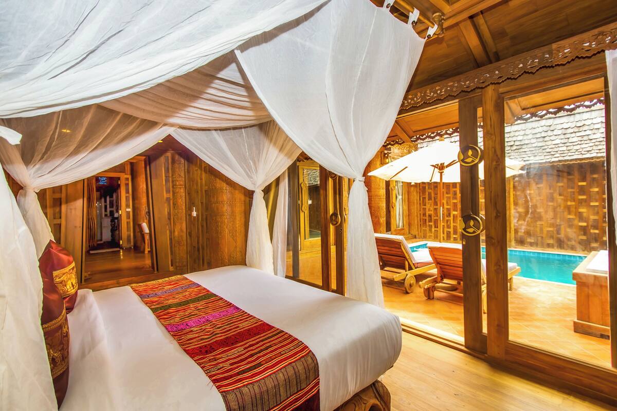A room with a bed, a pool view, and a wooden interior.