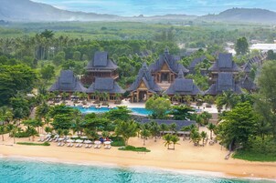 Un resort con varias edificaciones, piscina y zona de playa.