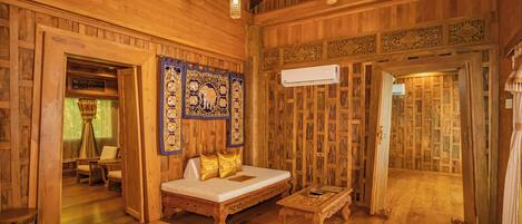 A wooden room with a bed, a table, and chairs.
