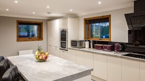 Een moderne keuken met witte kastjes, een granieten aanrechtblad en roestvrijstalen apparatuur.