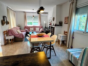 A cozy living area with a sofa, a dining table, and a fireplace.