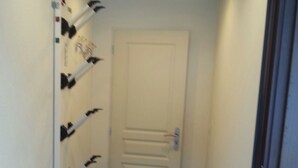 A narrow hallway with a white door at the end, a radiator on the right, and a wooden bench on the left. - Detached chalet on the slopes and near the village, for winter sports & summer holidays (La Norma)