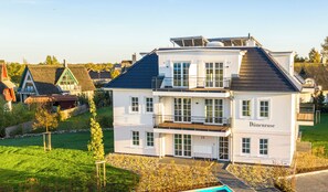 A modern building with a name sign 'Dünenrose'. - Comfortable 3-room apartment, sea view balcony and 200 m to the beach (Börgerende)
