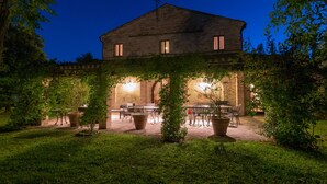 Een stenen gebouw met een overdekte patio en terrasmeubilair.
