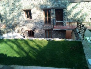 Ein Gebäude aus Stein mit einem kleinen Balkon, einer Holztür und einem Fenster.