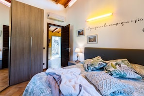 A bedroom with a bed, a nightstand, a wall-mounted lamp, and a wardrobe. - Monet House surrounded by nature and the sea (Bordighera)
