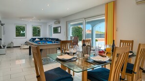 Un comedor moderno con mesa de billar, sillas de comedor y una mesa dispuesta para una comida.