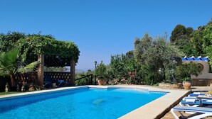 A clear blue swimming pool with lounge chairs and a pergola covered with greenery. - Self catering El Rincón de Carmen for 4 people (Rute)