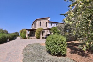 A stone house with a red roof, a satellite dish, and a paved driveway leading to a covered porch. - Villa Athene-modern stone villa with sea views, close to the beach, heated pool (Rethymno)
