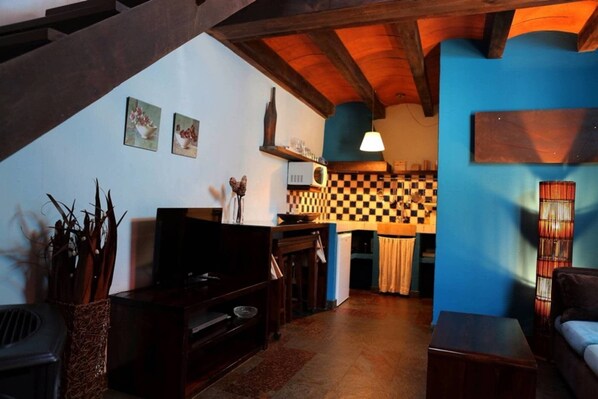 Un espacio de sala acogedor con chimenea, muebles de madera y un patrón de pared a cuadros.