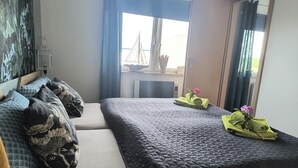 Ein Hotelzimmer mit Bett, Schreibtisch und einem Fenster mit Vorhängen.